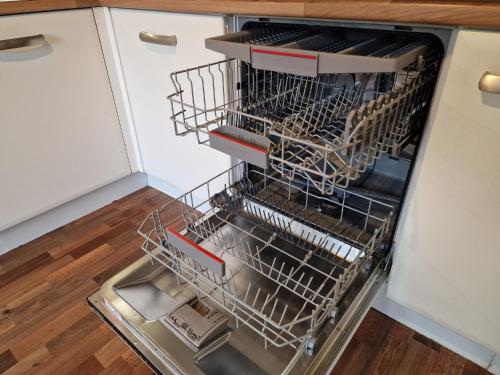 an empty dishwasher with dishes inside of it at Hornscroft Park - Contemporary luxury and style in Hull