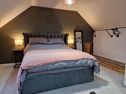 a bedroom with a large bed with two lamps on either side at Hornscroft Park - Contemporary luxury and style in Hull