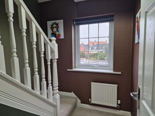 a stairway with a window and a stair case at Hornscroft Park - Contemporary luxury and style in Hull