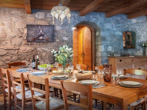 une salle à manger avec une table et des chaises en bois dans l'établissement La Ferme du Cortet - OVO Network, à Thônes