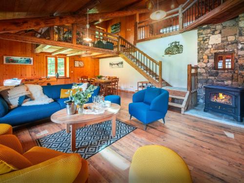 een woonkamer met een blauwe bank en een open haard bij La Ferme du Cortet - OVO Network in Thônes