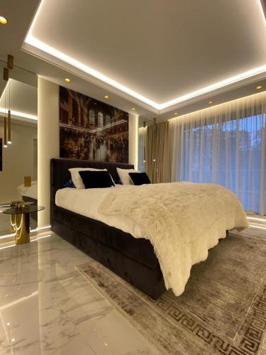 une chambre avec un grand lit et une grande fenêtre dans l'établissement Luxury Flat Paris 16 Tour Eiffel, à Paris