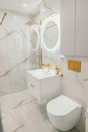 a white bathroom with a toilet and a sink at Exclusiv Est One in Drobeta-Turnu Severin