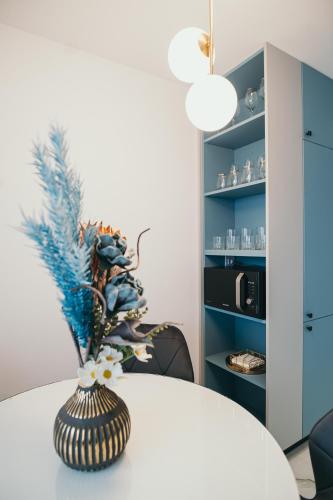 a vase with flowers on a table in a room at Exclusiv Est One in Drobeta-Turnu Severin