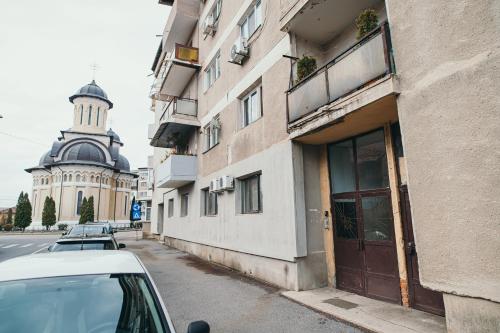 a car parked in front of a building on a street at Exclusiv Est One in Drobeta-Turnu Severin