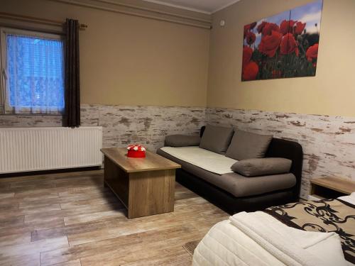 a living room with a couch and a table at Kék Lagúna Wellness Apartmanok in Egerszalók