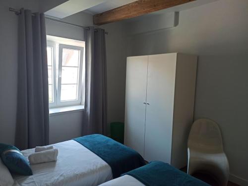 a bedroom with a bed and a cabinet and a window at Superbe appartement 3 chambres et grande pièce à vivre in Wasselonne