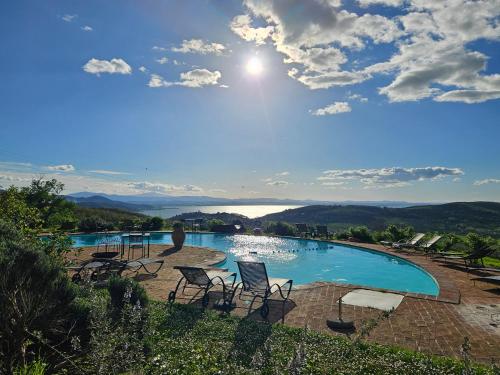 a pool with chairs and a view of the mountains at EcoResort Il Cantico della Natura in Magione