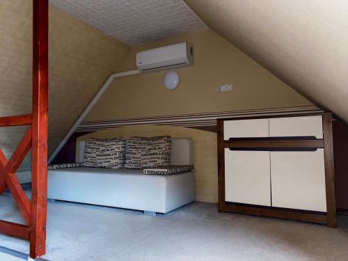 a attic room with a bed and a air conditioner at Kék Lagúna Wellness Apartmanok in Egerszalók
