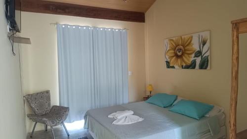 a bedroom with a bed with towels on it at Casa Dos Artistas in Penedo