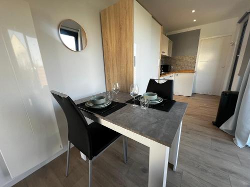 a dining room with a table and chairs and a room at Conteneur Design Avec Jacuzzi - Bord de Forêt in Saint-Amand-les-Eaux