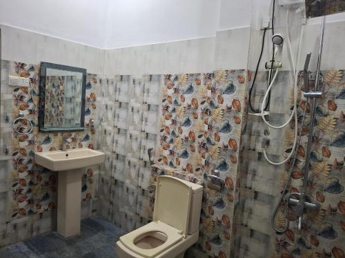 a bathroom with a shower and a toilet and a sink at Dew Drops Nature Villa in Parakaduwa