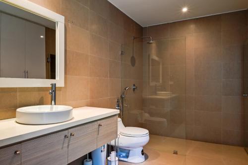 a bathroom with a sink and a toilet and a shower at Duplex de lujo in Same