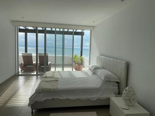 a bedroom with a bed and a view of the ocean at Duplex de lujo in Same
