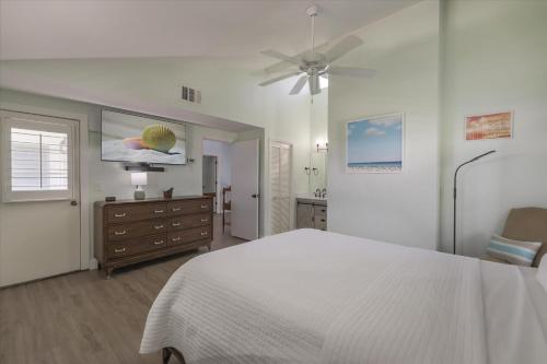 a bedroom with a bed and a dresser and a ceiling fan at Sunshine Lagoon in Sanibel