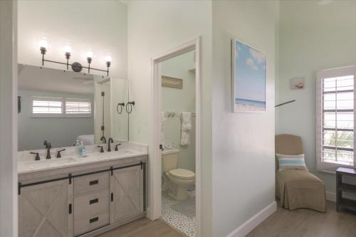 a bathroom with a sink and a toilet and a mirror at Sunshine Lagoon in Sanibel