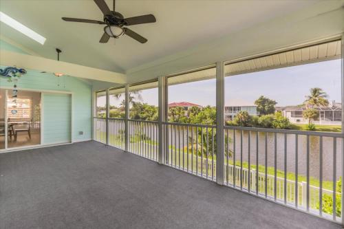 a large screened in porch with a ceiling fan at Sunshine Lagoon in Sanibel