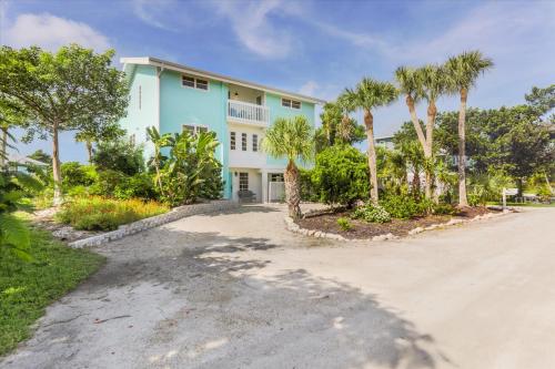 a house with palm trees in front of a driveway at Sunshine Lagoon in Sanibel
