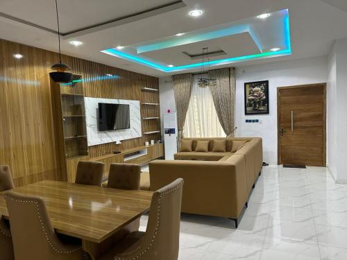 Un comedor con una mesa y sillas y un sofá. en Clara Court, en Lekki