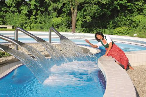 a woman is standing in front of a fountain at Best Western Aparthotel Birnbachhöhe in Bad Birnbach
