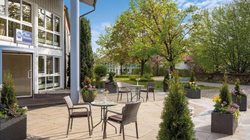 a patio with tables and chairs in front of a building at Best Western Aparthotel Birnbachhöhe in Bad Birnbach