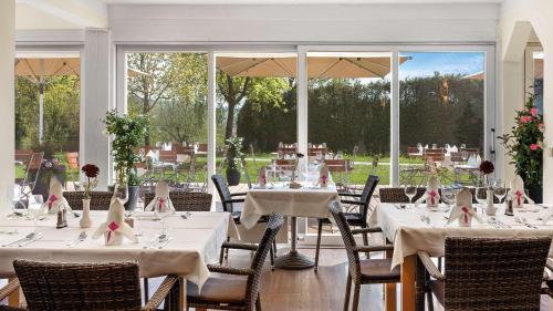 a dining room with white tables and chairs at Best Western Aparthotel Birnbachhöhe in Bad Birnbach