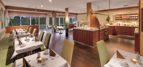 a restaurant with white tables and chairs and a bar at Best Western Aparthotel Birnbachhöhe in Bad Birnbach