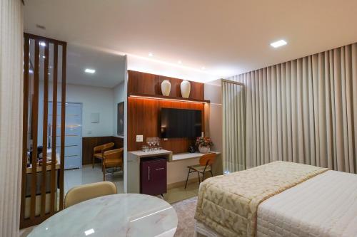 a hotel room with a bed and a table and a kitchen at Ananda Pousada in Pirenópolis