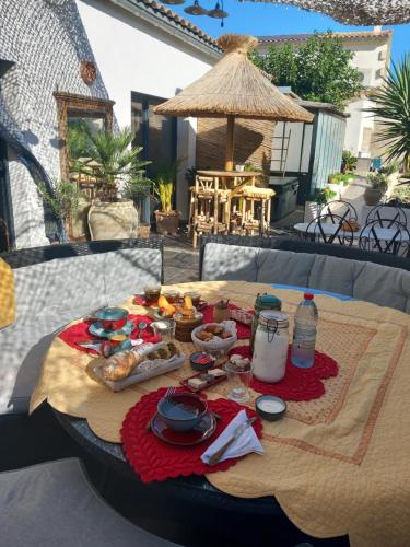 une table avec de la nourriture et des boissons sur une terrasse dans l'établissement La P'tite Maison, à Jonquières-et-Saint-Vincent