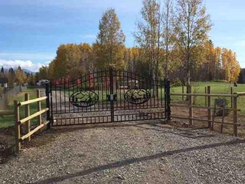 a black gate with a fence and a field at Simcoe B&B - Incredible vacation suite in Smithers