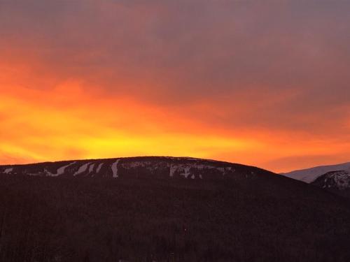 a painting of a sunset on top of a mountain at Simcoe B&B - Incredible vacation suite in Smithers
