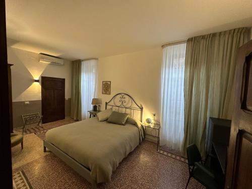 a bedroom with a bed and a television in it at L'Altro Sapore Rooms in Pitigliano