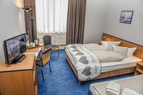 a hotel room with a bed and a desk at Best Western Comfort Business Hotel Düsseldorf-Neuss in Neuss