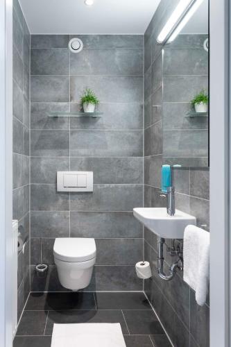 a bathroom with a toilet and a sink at Best Western Hotel am Europaplatz in Königsbrunn