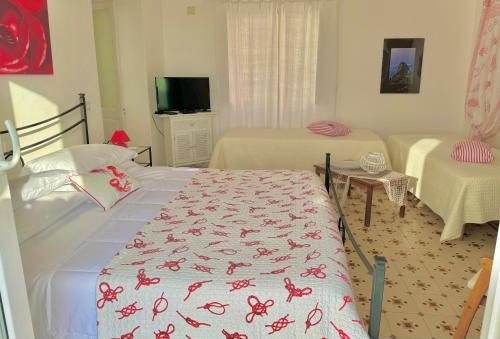 a bedroom with two beds and a table and a tv at PonzaSmeralda Le Forna in Ponza