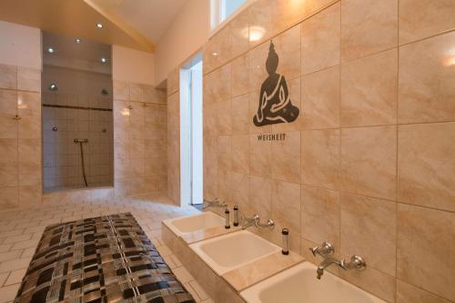 a bathroom with a tub and a sink and a shower at Sure Hotel by Best Western Rhoen Garden in Poppenhausen