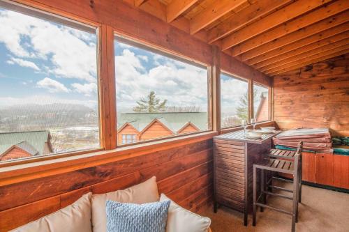 a room with a desk and a chair and windows at Moonlight Lodge Family Cabin in Pigeon Forge
