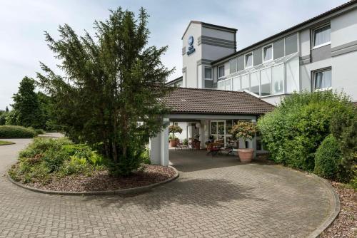 a building with a tree in front of it at Best Western Hotel Peine Salzgitter in Peine