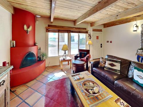 a living room with a leather couch and a fireplace at Artist Road #7 in Santa Fe