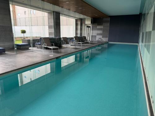 a swimming pool with blue water in a building at Increíble alojamiento en Santa Fe, CDMX con alberca, gym y estacionamiento in Mexico City