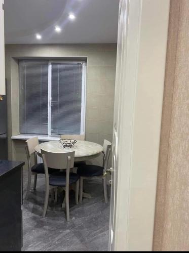 a dining room with a table and chairs and a window at New design apartment in Rustavi
