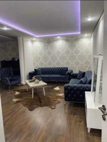 a living room with blue couches and a table at New design apartment in Rustavi