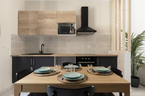 une cuisine avec une table en bois et 4 couverts dans l'établissement T3 house in the heart of Carcassonne, à Carcassonne