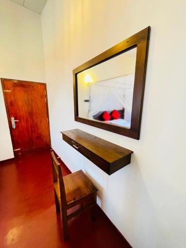 a mirror on the wall of a room with a chair at Serandib Beach Villa in Weligama