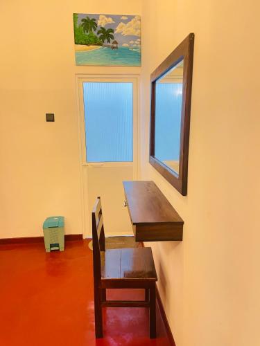 a room with a desk and a chair and a mirror at Serandib Beach Villa in Weligama