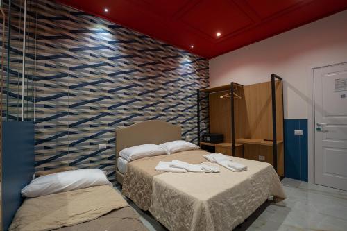 Postel nebo postele na pokoji v ubytování GreRos H. Rooms Napoli Centro by Clapa Group Dislocated Hospitality