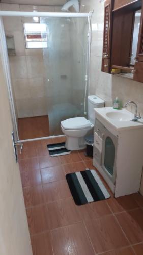 a bathroom with a toilet and a sink and a shower at Kitnet geminada próximo da praia in Torres