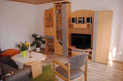 a living room with a couch and a table with a television at Ferienwohnungen Albrecht in Kloster