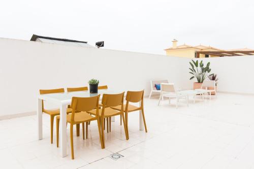 a dining room with a white table and chairs at D Wan Deluxe Apartments in Baleal