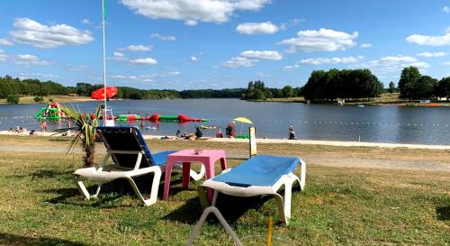 a group of chairs and a table next to a lake at Gites Limousin - La Haute in Videix